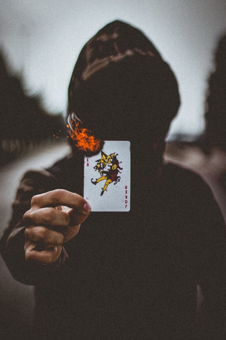a person wearing hoodie holding a burning card
