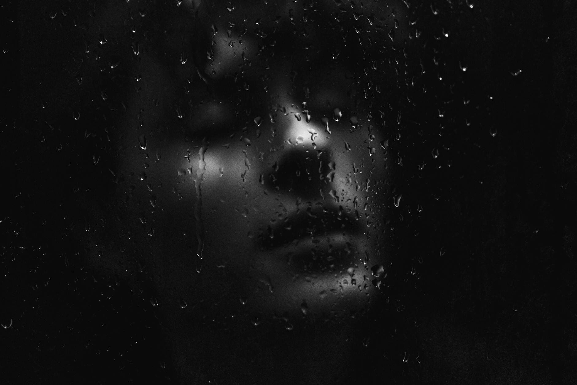 woman face behind wet glass